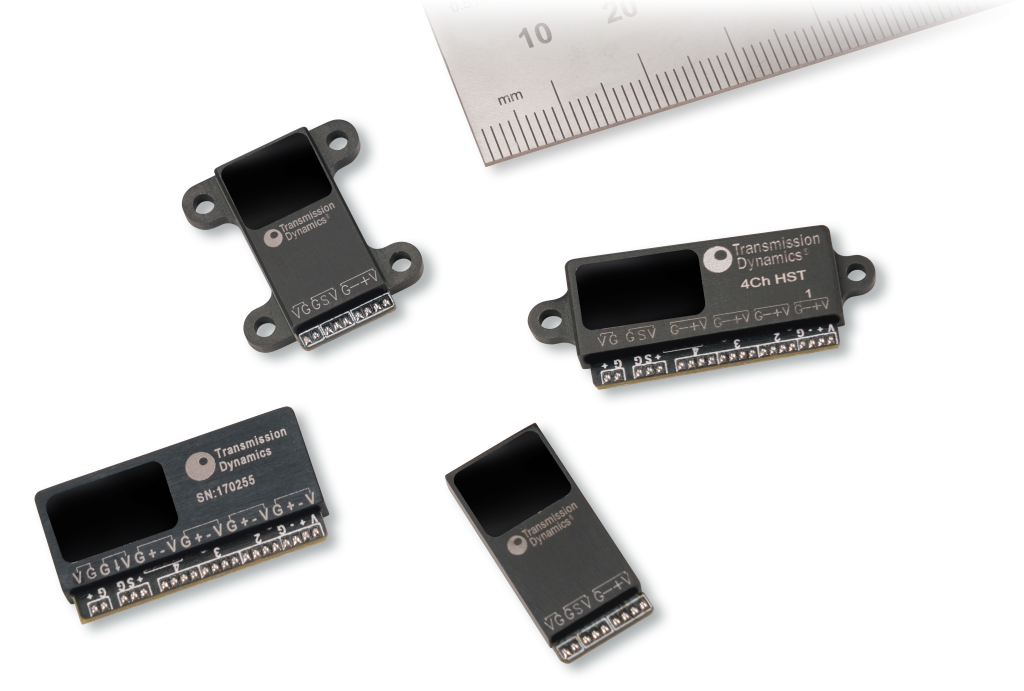 Image of four High Speed Telemetry units, together with a metric ruler to demonstrate scale.