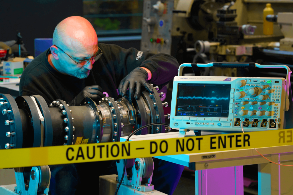 Engineer testing custom sensor equipment using an oscilloscope
